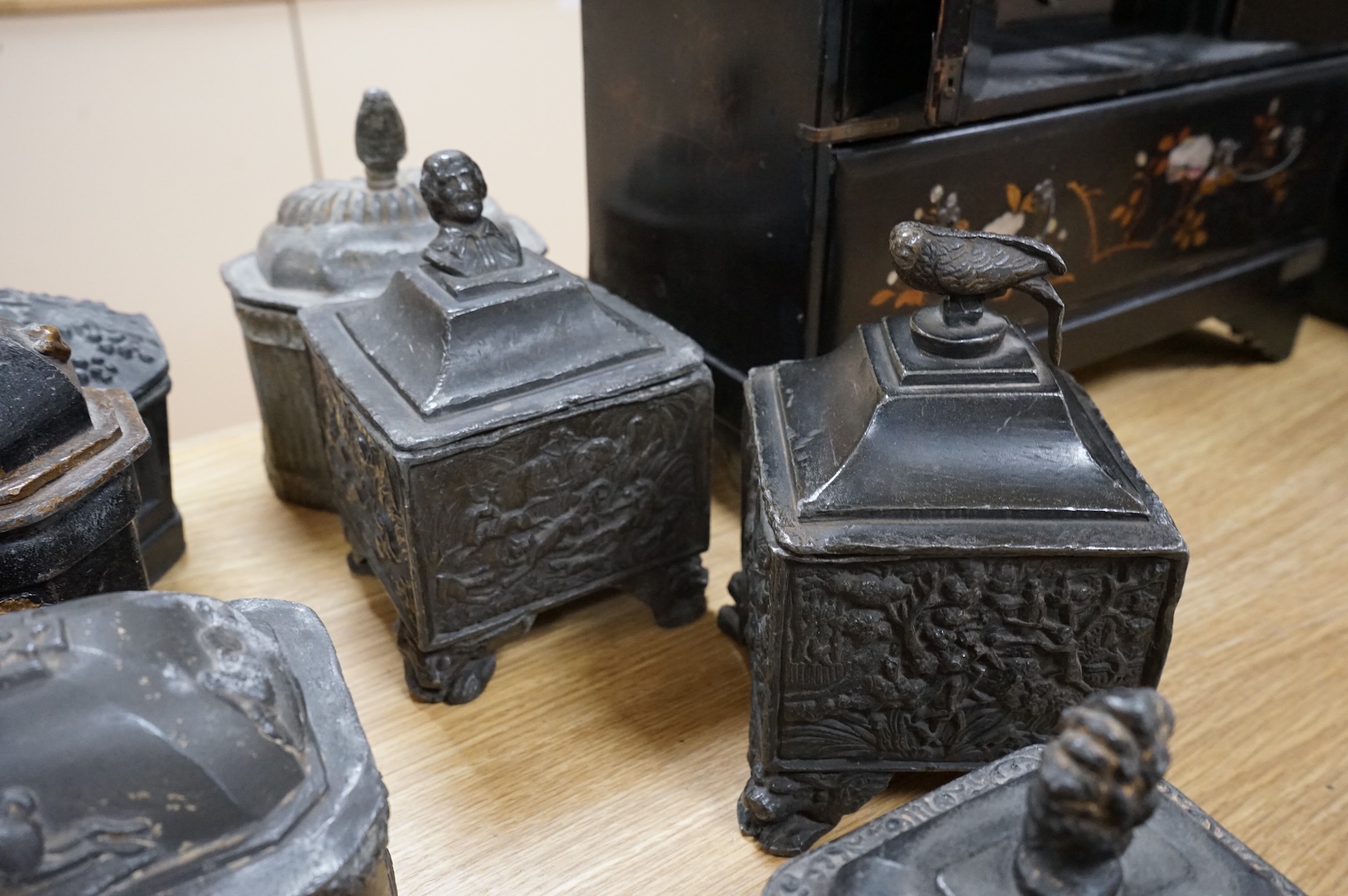 A collection of ten early 19th century lead tobacco boxes, one in the form of a monument with lion knop, largest 14cm wide